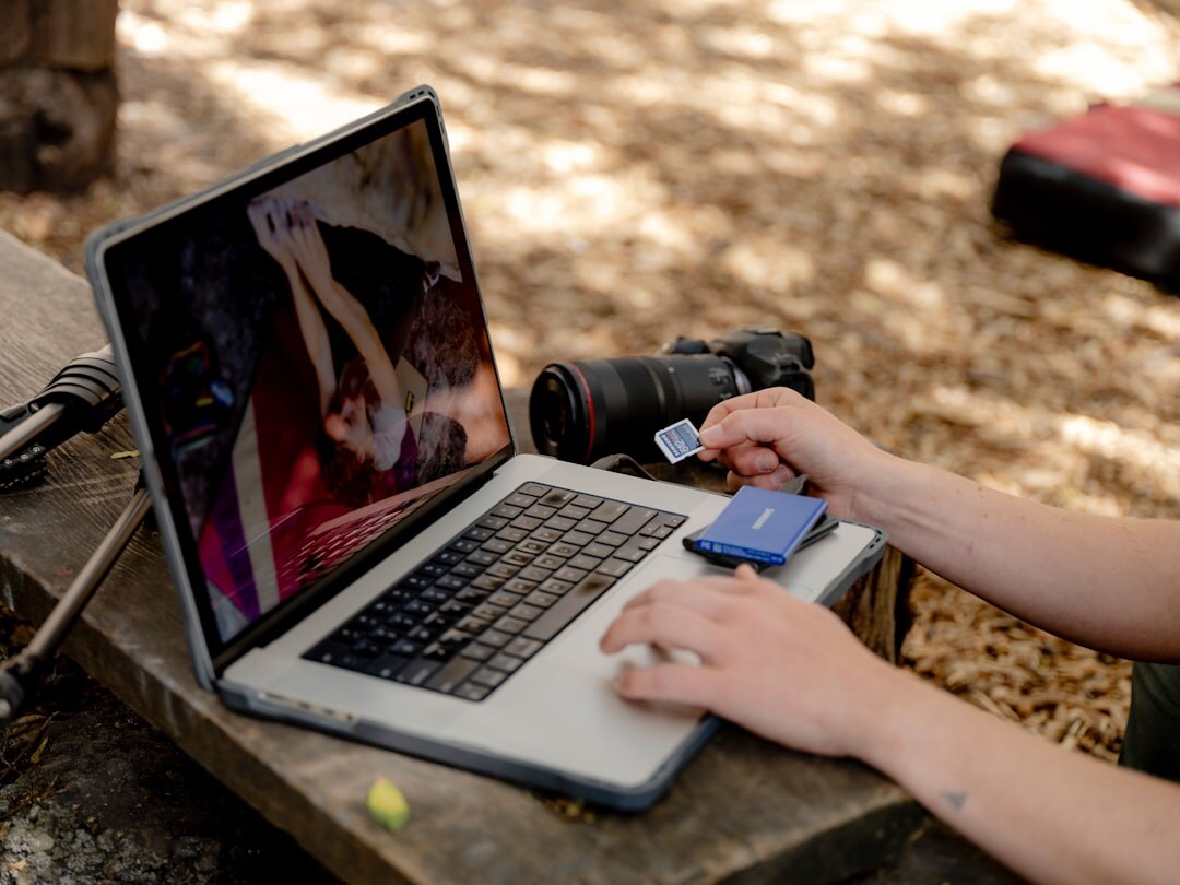 Hands editing video footage on a laptop timeline